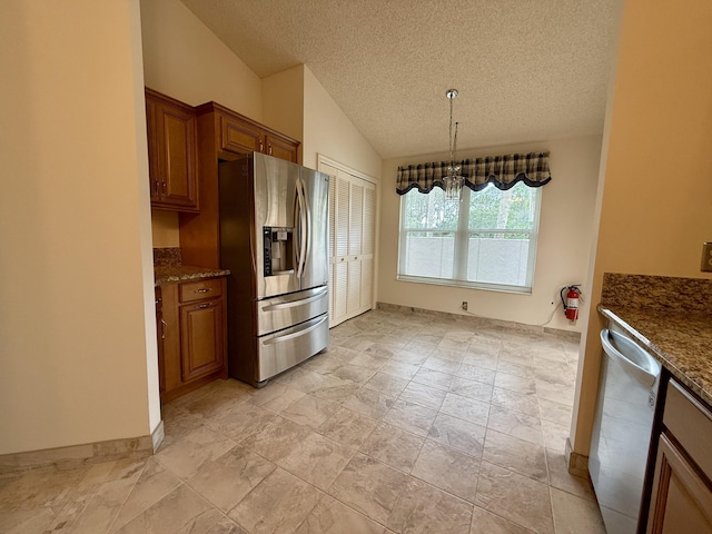 kitchen featuring lofted ceiling, hanging light fixtures, dark stone countertops, a textured ceiling, and appliances with stainless steel finishes