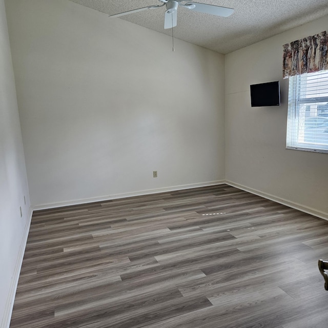 spare room featuring wood-type flooring, ceiling fan, and a textured ceiling