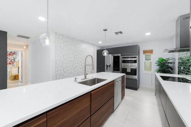 kitchen with extractor fan, sink, stainless steel appliances, and pendant lighting