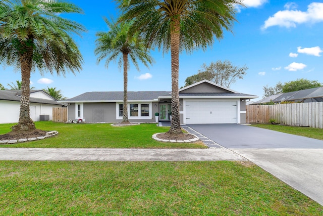 ranch-style home featuring a front lawn, cooling unit, and a garage