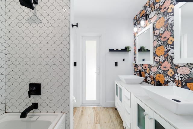 bathroom with a bath, hardwood / wood-style flooring, and vanity