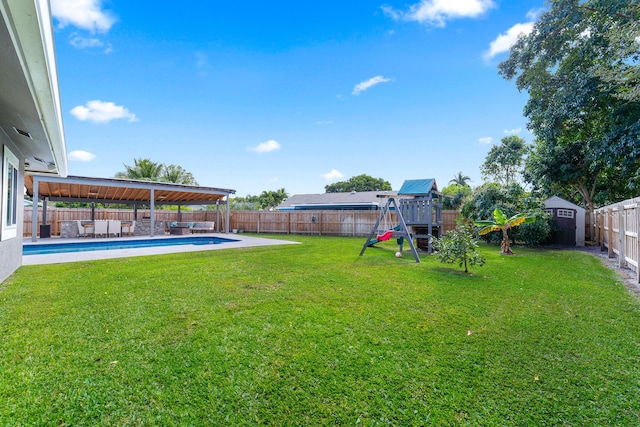 view of yard with a playground and a storage shed