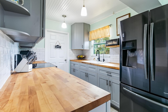 kitchen featuring pendant lighting, sink, gray cabinets, fridge with ice dispenser, and wood counters