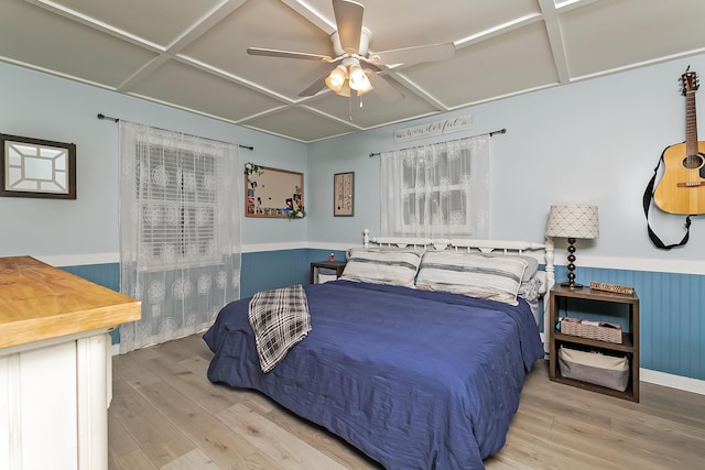 bedroom with ceiling fan, wood-type flooring, and coffered ceiling