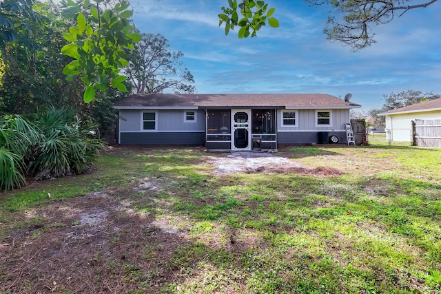 back of house featuring a lawn and a sunroom