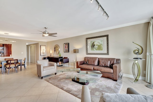 tiled living room featuring ceiling fan, ornamental molding, and track lighting