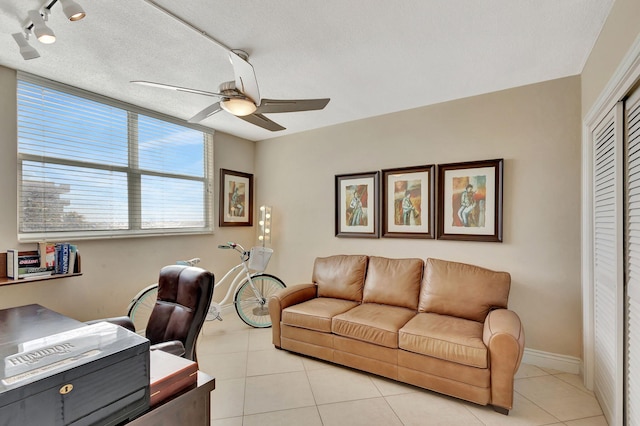 tiled home office featuring ceiling fan and a textured ceiling