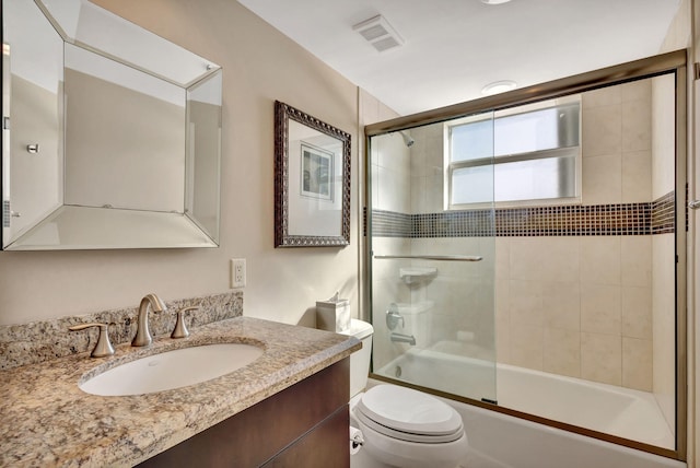 full bathroom with toilet, vanity, and bath / shower combo with glass door