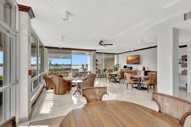 interior space featuring expansive windows, ceiling fan, and a textured ceiling