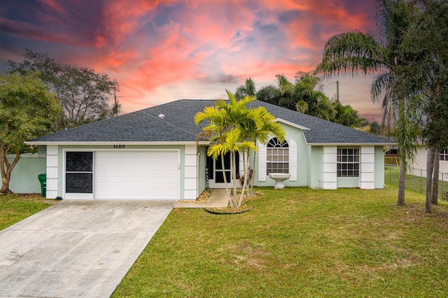 single story home featuring a garage and a lawn