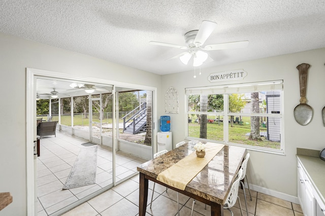 dining room with ceiling fan, a textured ceiling, and light tile patterned floors