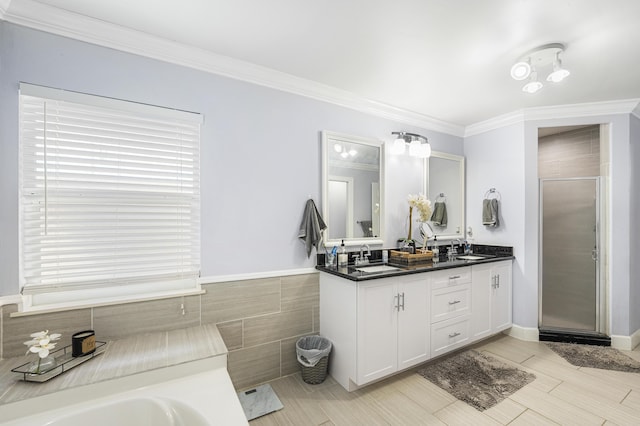 bathroom featuring tile walls, vanity, ornamental molding, and independent shower and bath