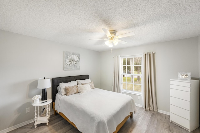 bedroom featuring wood-type flooring, a textured ceiling, and ceiling fan