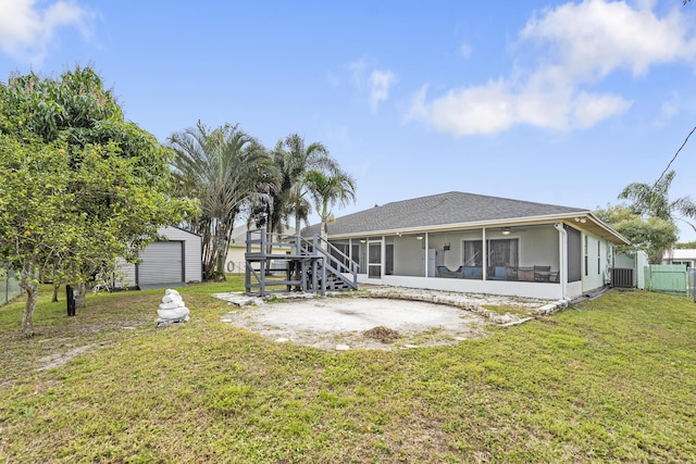 rear view of house featuring a shed, central AC, a yard, and a sunroom