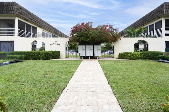 view of home's community with a mail area and a lawn