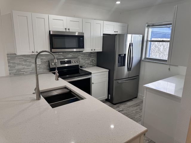 kitchen with decorative backsplash, sink, white cabinetry, and appliances with stainless steel finishes