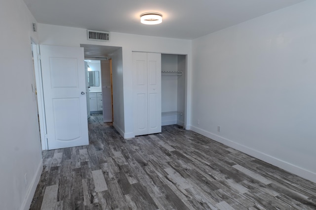 unfurnished bedroom featuring a closet and dark hardwood / wood-style floors