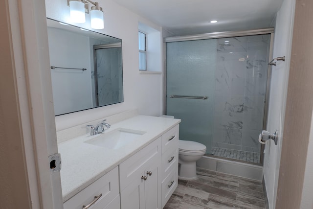 bathroom featuring vanity, toilet, wood-type flooring, and an enclosed shower