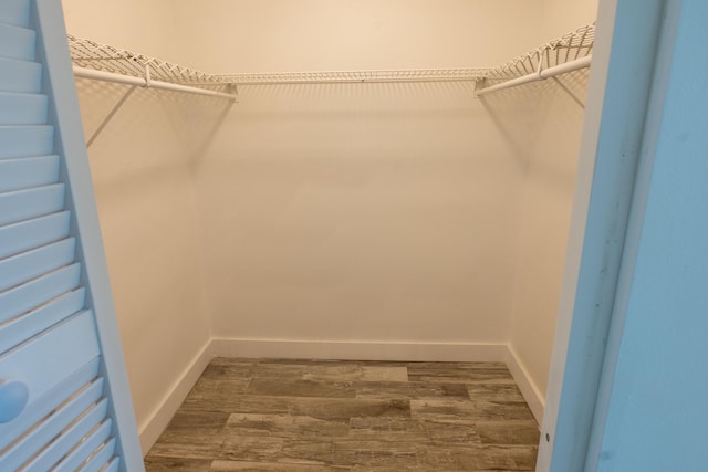 walk in closet with dark wood-type flooring