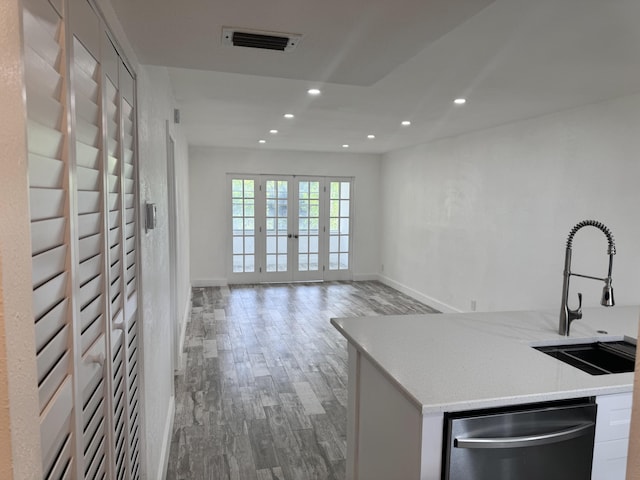 kitchen with dishwasher, sink, light wood-type flooring, white cabinets, and french doors