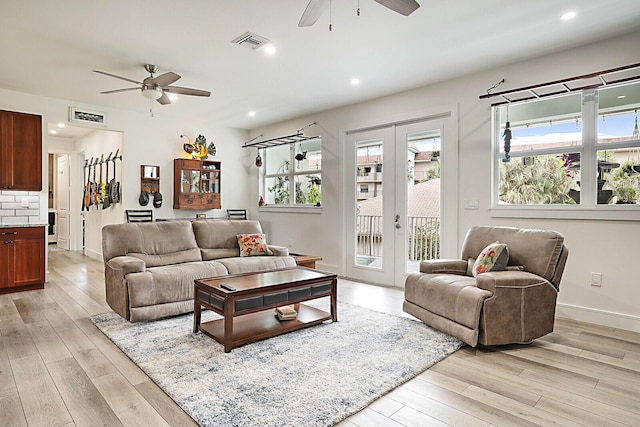 living room featuring ceiling fan, light hardwood / wood-style floors, and french doors