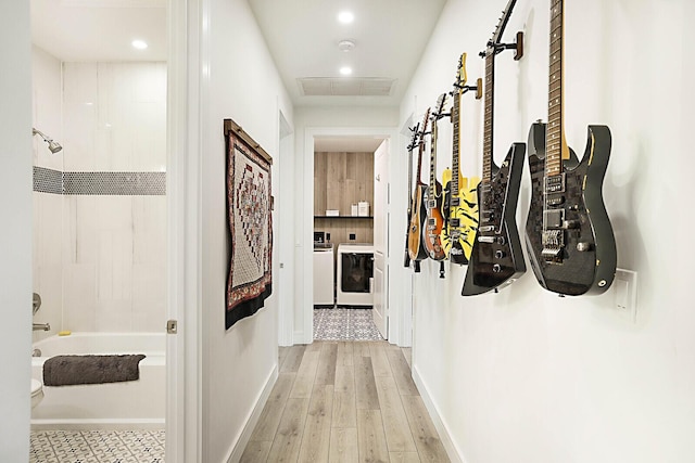 corridor with washer and clothes dryer and light hardwood / wood-style floors