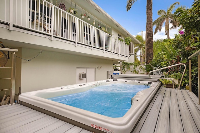 view of pool with hot tub deck surround