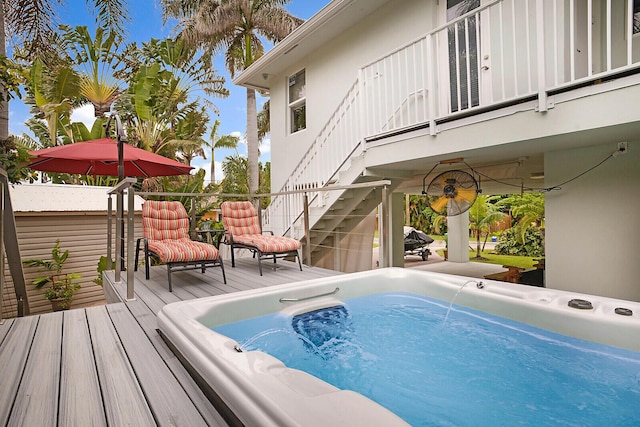 view of swimming pool with stairway, a deck, and an outdoor hot tub