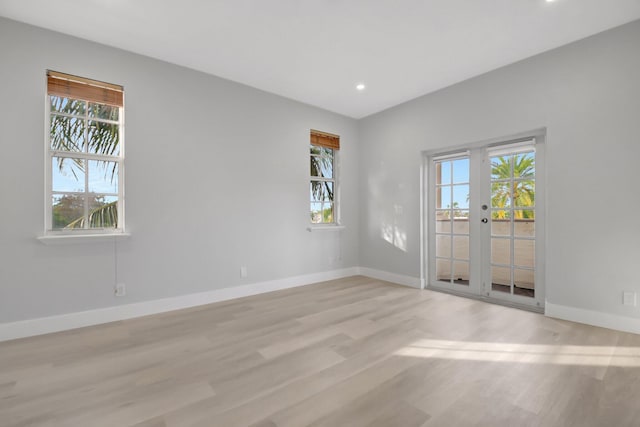 empty room featuring french doors and light hardwood / wood-style flooring