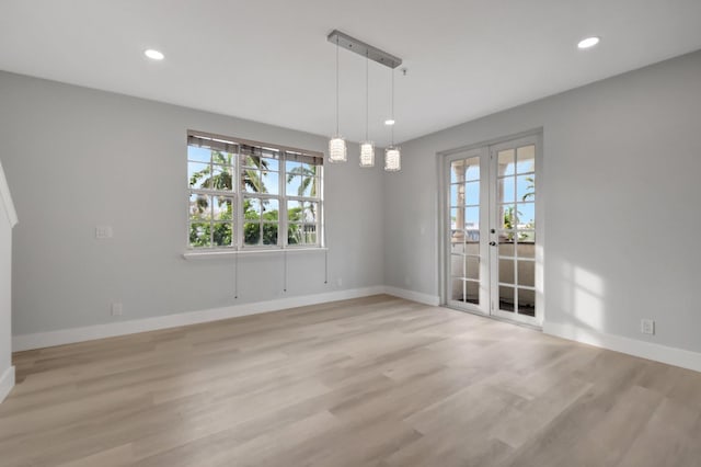 unfurnished dining area featuring french doors and light hardwood / wood-style floors