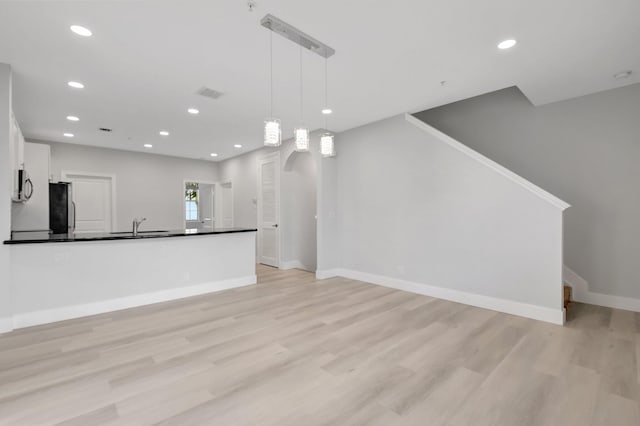 unfurnished living room featuring baseboards, visible vents, light wood-style floors, and recessed lighting