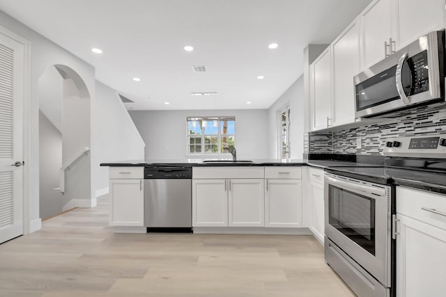 kitchen with appliances with stainless steel finishes, sink, and white cabinets