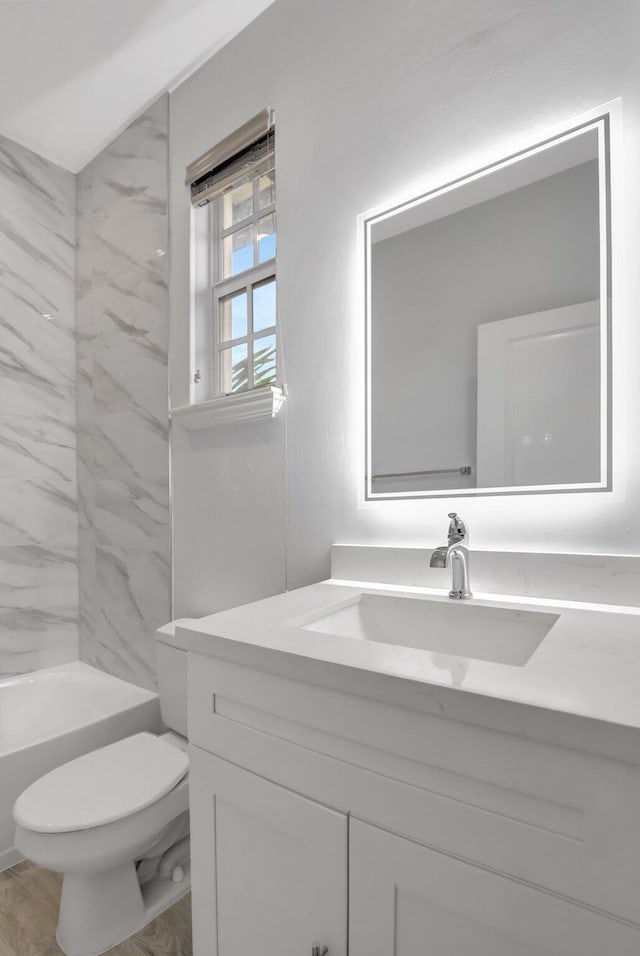 full bathroom featuring vanity, wood-type flooring, bathtub / shower combination, and toilet