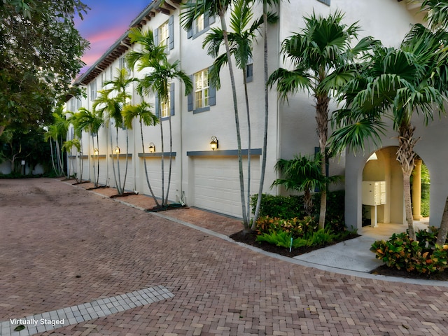 property exterior at dusk featuring a garage