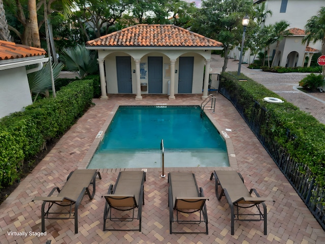 view of pool with an outbuilding and a patio