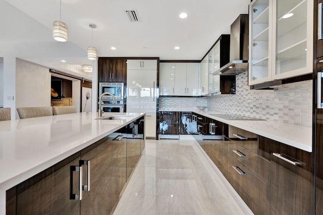 kitchen with wall chimney range hood, sink, white cabinetry, hanging light fixtures, and black electric cooktop