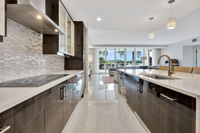 kitchen with wall chimney exhaust hood, sink, decorative light fixtures, dark brown cabinets, and black electric cooktop