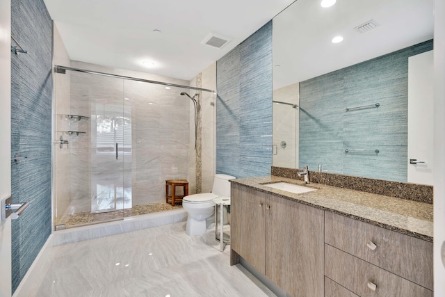 bathroom featuring tile walls, vanity, a shower with door, and toilet