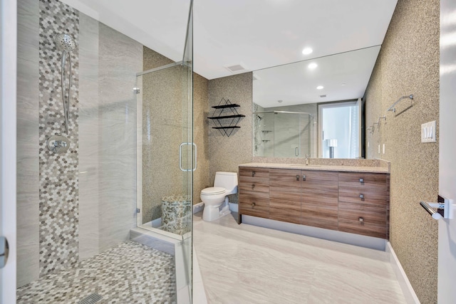 bathroom with vanity, a shower with door, and toilet