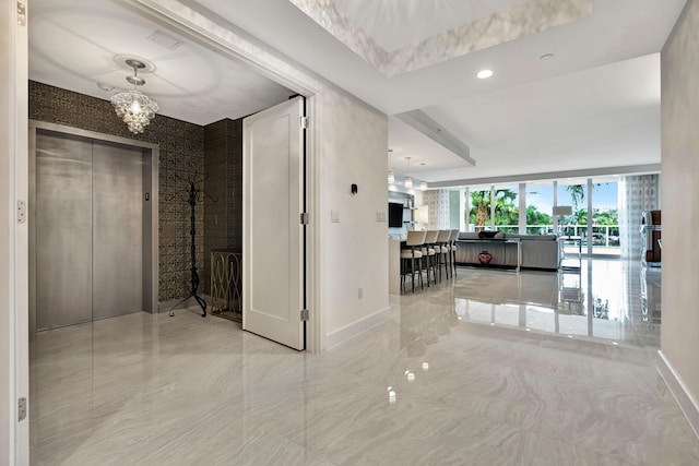 hallway featuring a chandelier and elevator