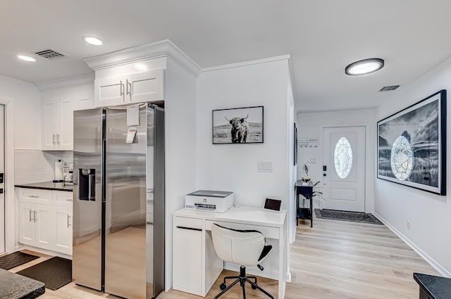 kitchen featuring tasteful backsplash, stainless steel fridge, white cabinetry, and light hardwood / wood-style floors