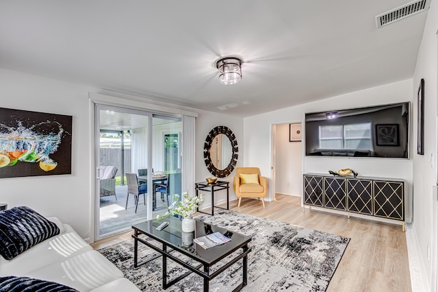 living room with light hardwood / wood-style flooring and lofted ceiling