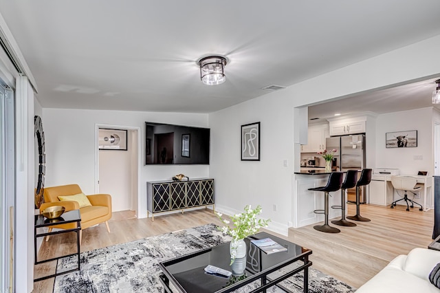 living room with light wood-type flooring and vaulted ceiling