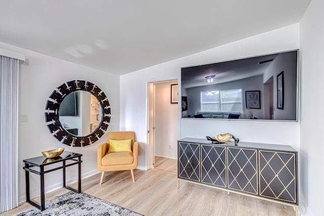 living area featuring vaulted ceiling and hardwood / wood-style floors