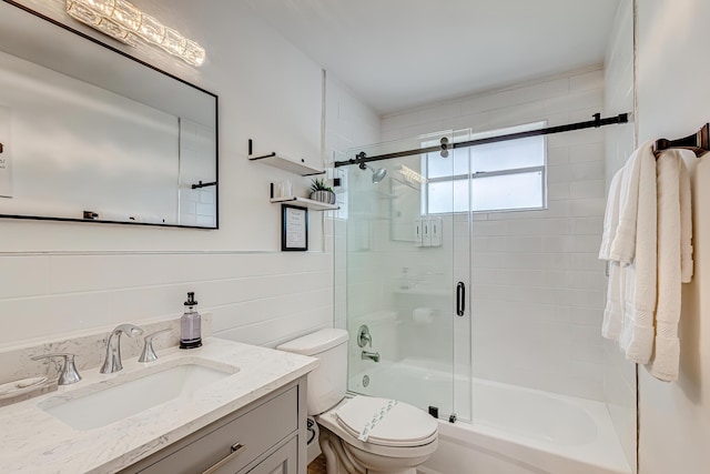 full bathroom with bath / shower combo with glass door, tile walls, toilet, and vanity