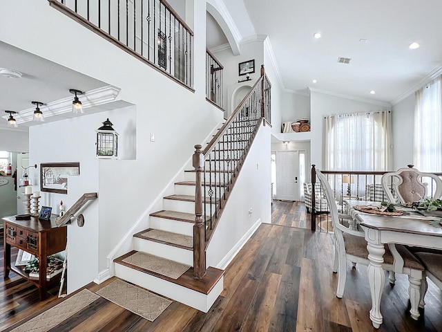 staircase with wood-type flooring and ornamental molding