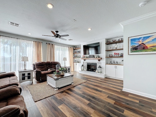 living room featuring ceiling fan, dark hardwood / wood-style floors, crown molding, and a textured ceiling