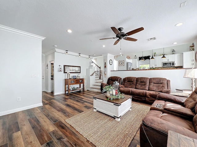 living room featuring ceiling fan, dark hardwood / wood-style flooring, a textured ceiling, and ornamental molding