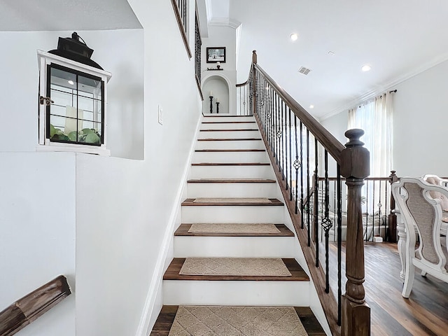 stairs featuring ornamental molding and hardwood / wood-style floors