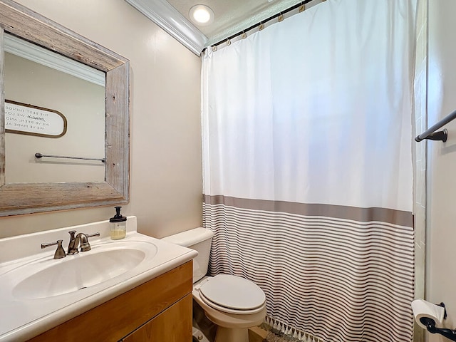 bathroom featuring toilet, ornamental molding, and vanity